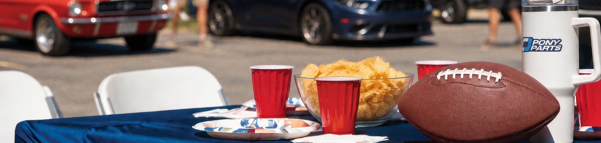 Food and beverages spread on a table during a tailgate