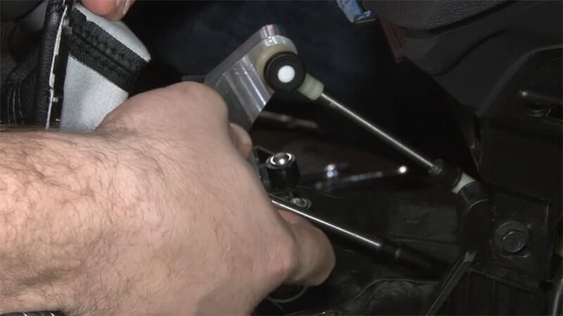 Mechanic attaching shift cables on a Ford Focus ST