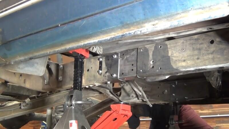 A close up of the underside of the frame being slide into place underneath the cab of the truck