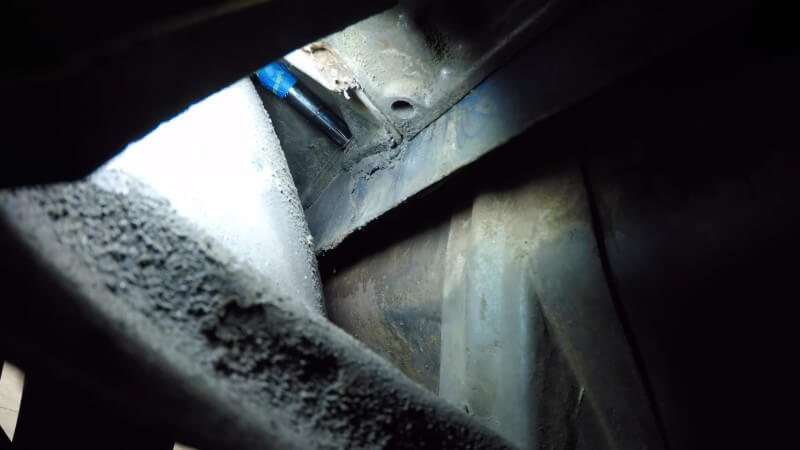 A close up of a swivel socket removing the lower heater box nut on a classic Chevy truck