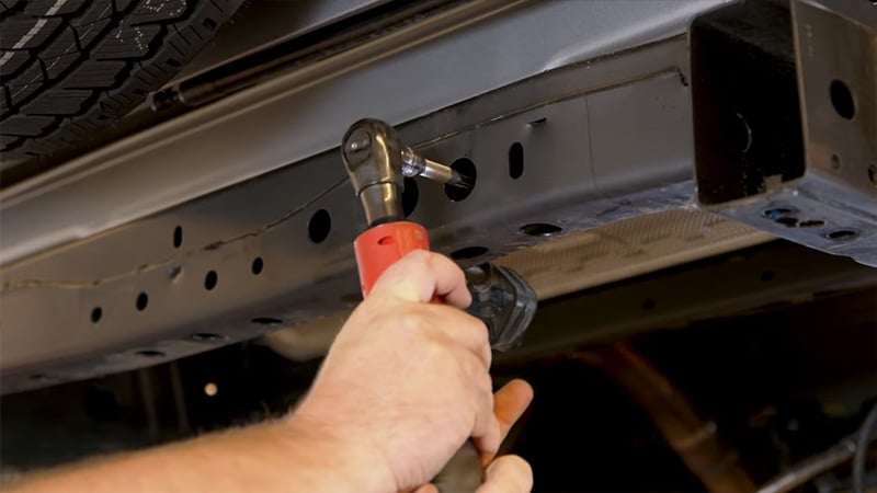 Loosening 6th gen Bronco's hanger arm bolts from behind bumper