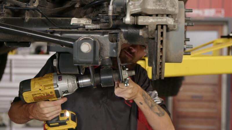 A mechanic removing the shock bolts holding the shock to the brake rotor