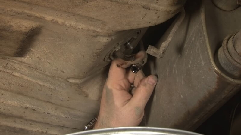Mechanic disconnecting the fuel sending unit from the fuel tank