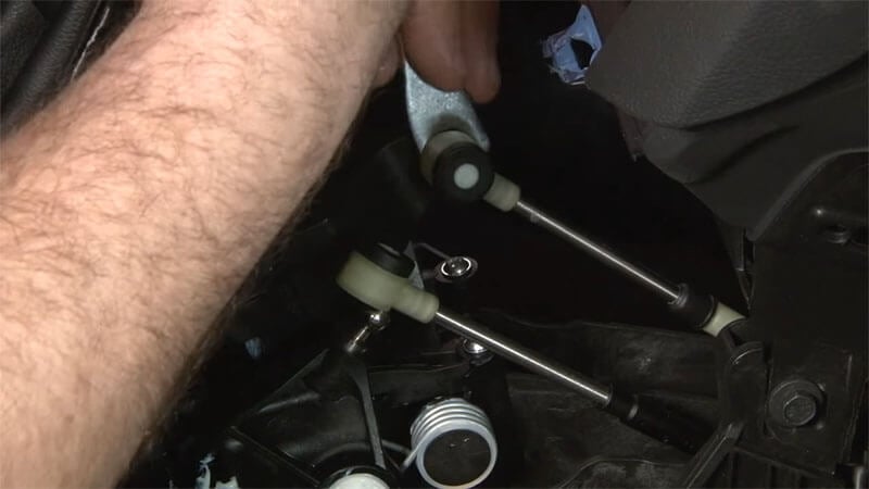 Mechanic disconnecting shifter cables on a Ford Focus ST