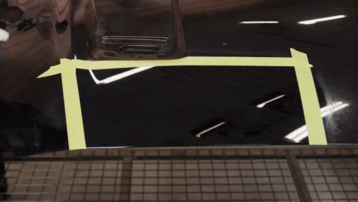 Claying a black Mustang hood with clay lube and a clay mitt