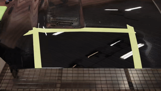 Prepping a black Mustang hood with a paint prep spray