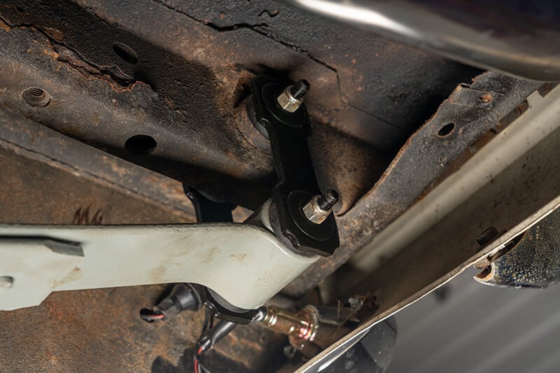 A close up shot of a leaf spring shackle attached to a classic Mustang