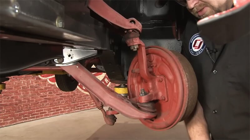 A close up of how the upper and lower control arms connect to the spindle on the back of the brake assembly