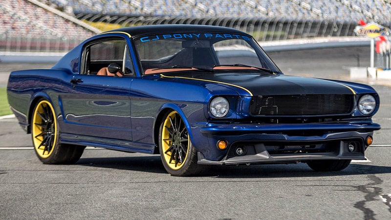 A wide angle shot of a blue and yellow classic Mustang that has been completely repainted and restored