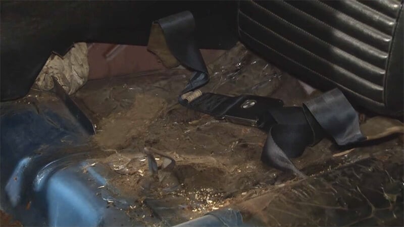 Dirt, debris, and rust underneath where the seat and carpet used to be