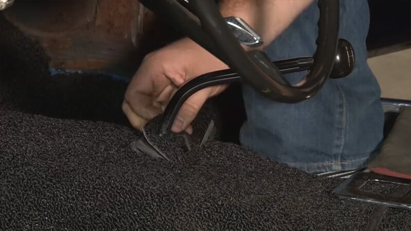 Bill pulls up square of carpet