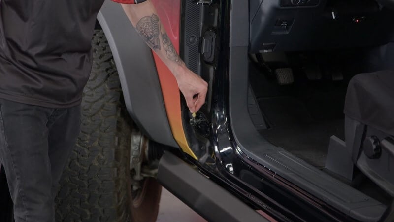 Inserting the door alignment pin on a modern Ford Bronco