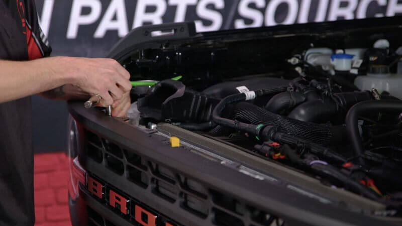 Mechanic removing the grille on a 2021 Ford Bronco