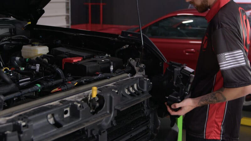 Mechanic installing new LED headlight on a 2021 Ford Bronco