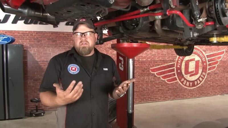 Ford Mustang on a Lift With an Oil Pan Underneath