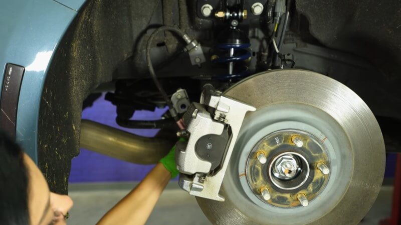 A mechanic reattaching the sway bar end link