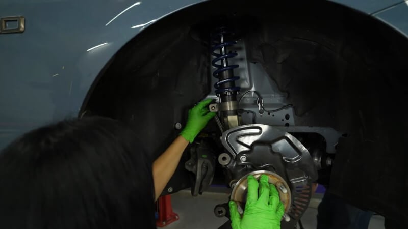 A mechanic reconnecting the sway bar link to the hub assembly