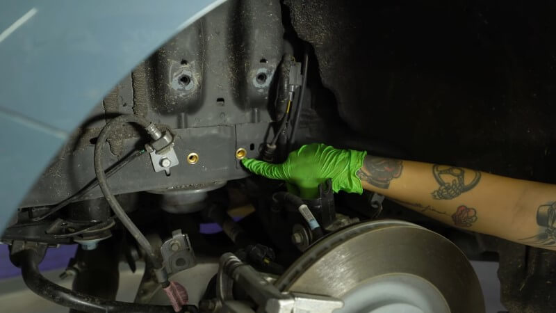 A mechanic pointing at the correctly installed riv nuts