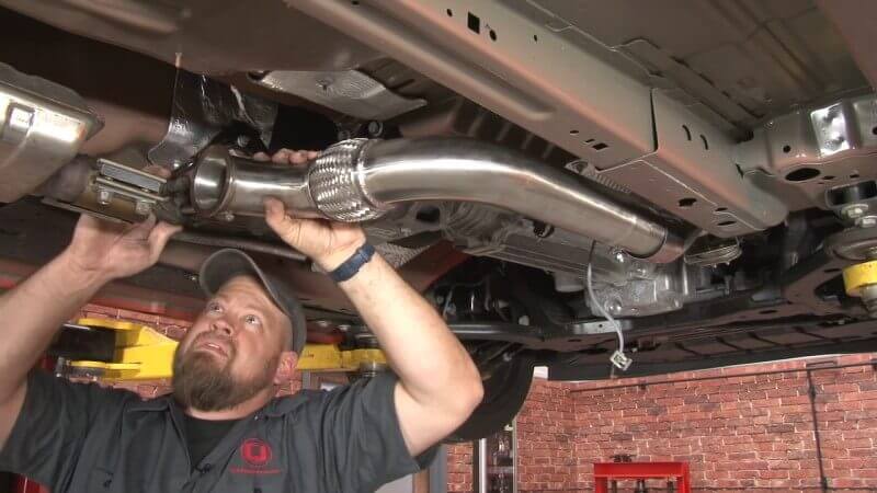 Mechanic connecting the secondary pipe to the front pipe on a Mustang EcoBoost