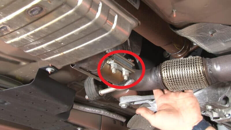 Mechanic loosening nuts attaching downpipe to resonator on a Mustang EcoBoost