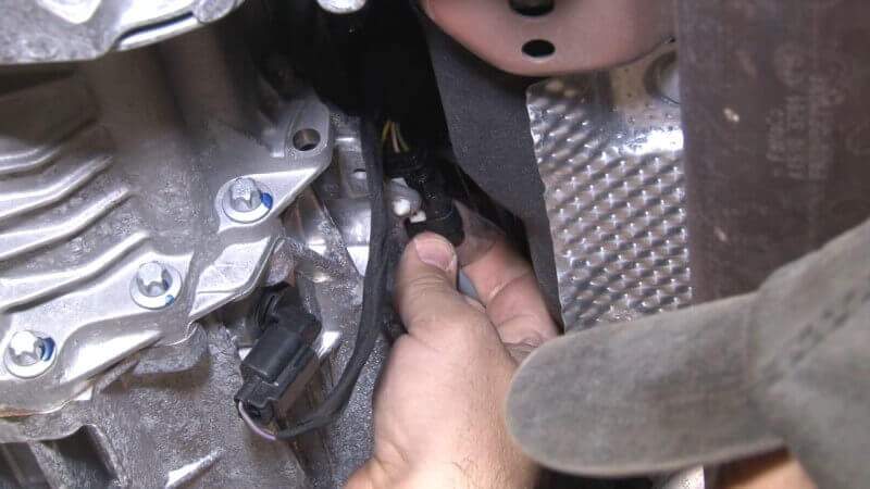 Mechanic disconnecting the downstream O2 sensor on a Mustang EcoBoost
