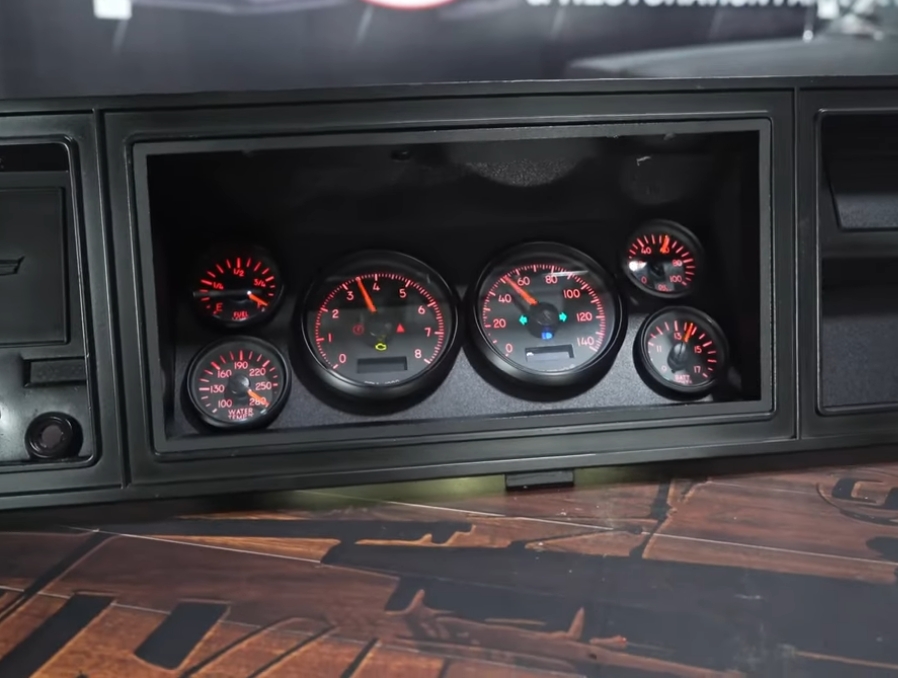 Aftermarket Chevy C10 gauges on a wooden table
