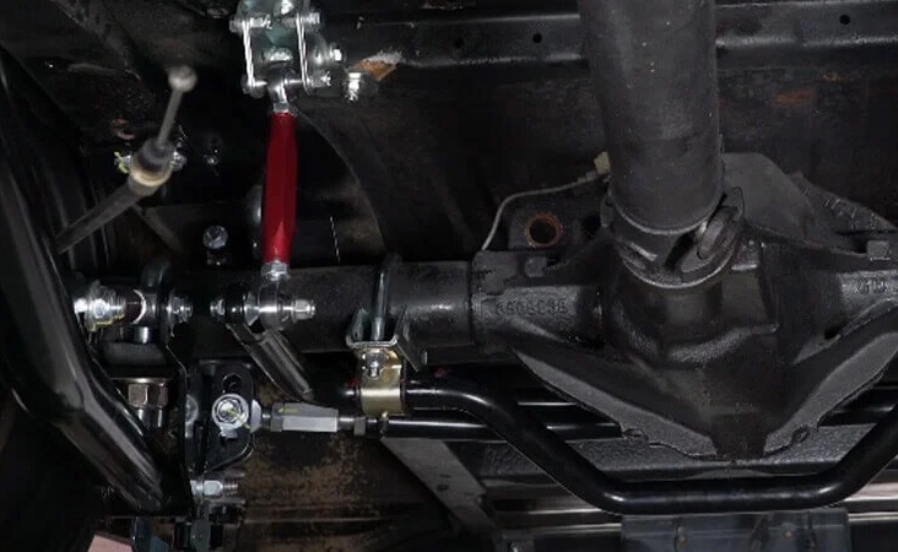 A close up shot of the underside of a Chevy C10 with modern suspension components installed